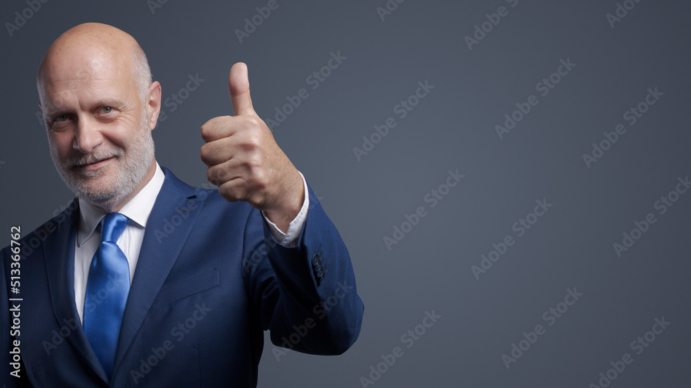 Corporate businessman giving a thumbs up Corporate businessman giving a thumbs up