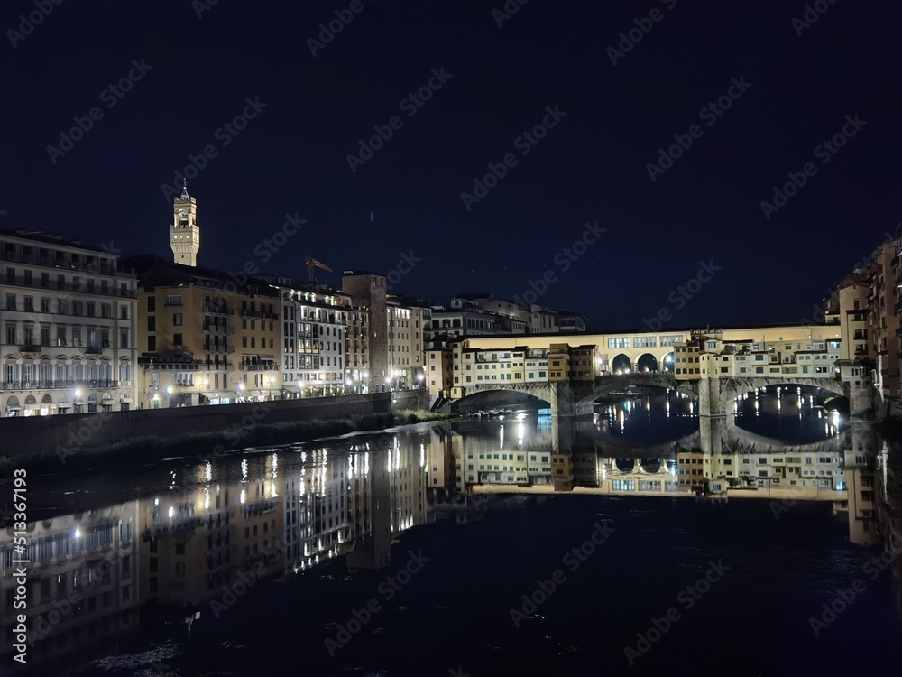 Night panorama of the bank of the Arno in Florence, Ponte Vecchio and the tower of Palazzo della Signoria in the background.