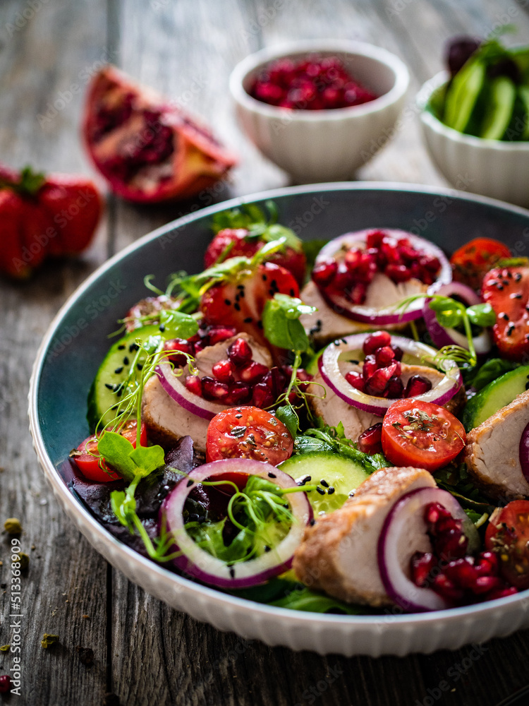Tasty salad - roast pork loin, cucumber, cherry tomatoes, pomegranate, strawberries and fresh, green vegetables on wooden table
Tasty salad - roast pork loin, cucumber, cherry tomatoes, pomegranate, strawberries and fresh, green vegetables on wooden table