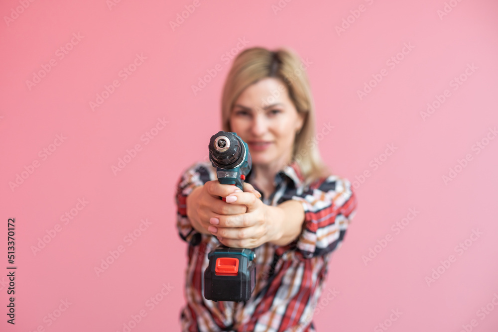 Woman with a drill. House renovation and repair concept. Woman with a drill. House renovation and repair concept.