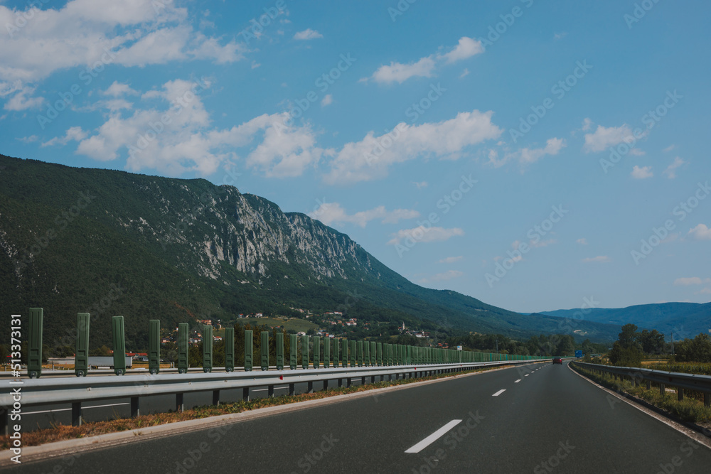 Beautiful scenic landscape on mountains covered with forests. View from the car window on a modern and high-quality highway.