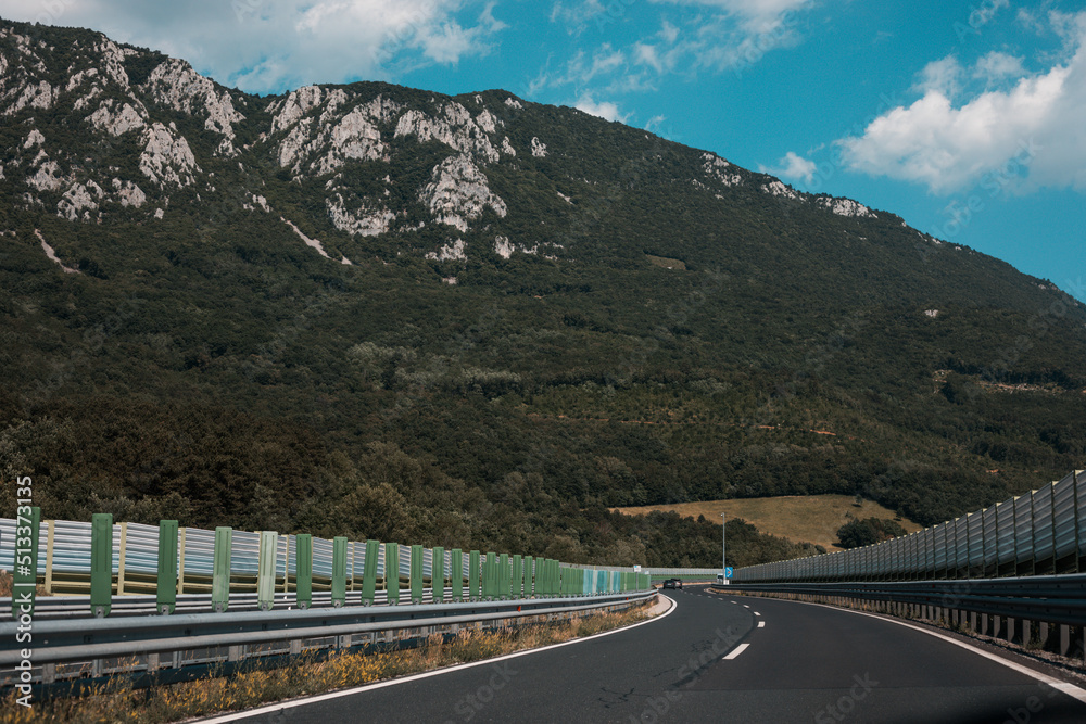 Obraz premium Beautiful scenic landscape on mountains covered with forests. View from the car window on a modern and high-quality highway.