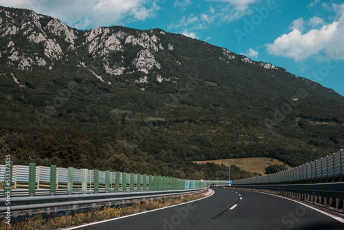 Beautiful scenic landscape on mountains covered with forests. View from the car window on a modern and high-quality highway.