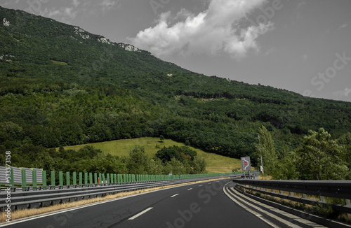 Beautiful scenic landscape on mountains covered with forests. View from the car window on a modern and high-quality highway.