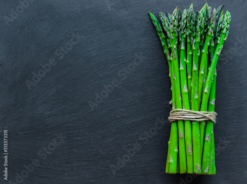 asparagus Green, juicy, fresh, on a black background, space for text, seasonal vegetables, vegetarian products, healthy eating, diet, ingredients for cooking, top view, layout