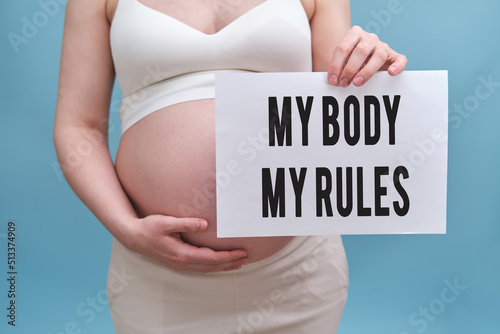 Obraz na plátne Text my body my rules and pregnant woman with a sheet of A4 paper in her hands,