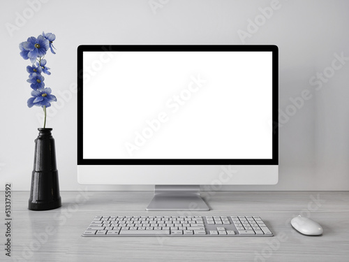 3d rendering mock up template of blank white screen of computer.Minimally designed room in gray and white tones.With blue flowers.