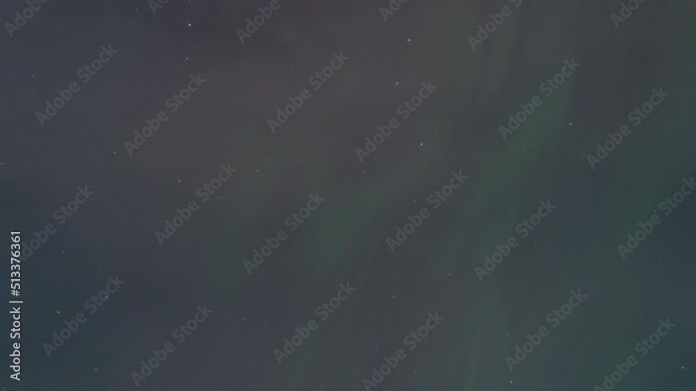 From below time lapse of green polar lights glowing in dark sky at night in Iceland
