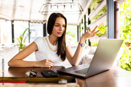 Beautiful young confused woman using laptop while drink coffee at cafe Free Download Beautiful young confused woman using laptop while drink coffee at cafe - GFXLoad