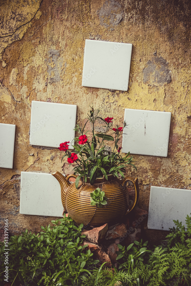 Old broken teapot and flowers. Eco-friendly garden design