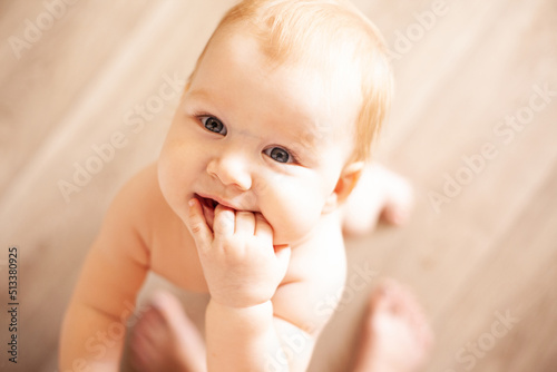 the infant boy looks up at his mother and smiles, asking for her arms. baby up to a year old.