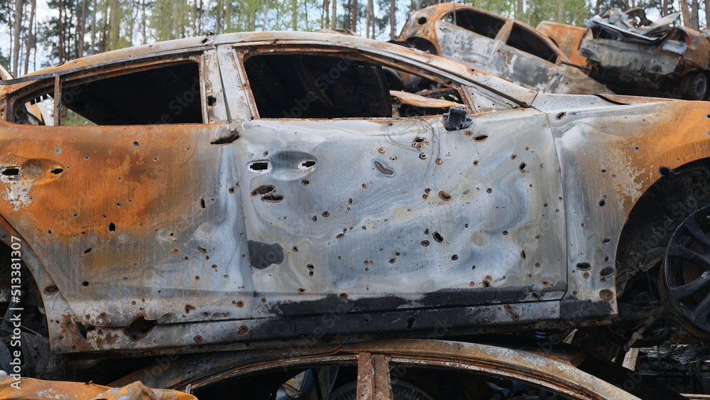 rusty burnt car, damaged by shrapnel from shells. Side view, Irpen, war in Ukraine, consequences.
