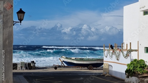 coast on lanzarote canary islands during sunset with high waves and fisher boat photo