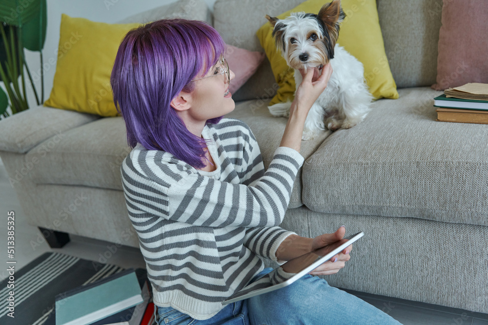 Cheerful teenage girl spending time with her little dog at home Cheerful teenage girl spending time with her little dog at home