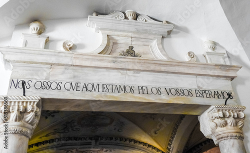 Evora, Portugal - August 03 2019: Bones Chapel in Evora. Entrance - written in Portuguese is the sentence:  "we bones that are here wait for yours"