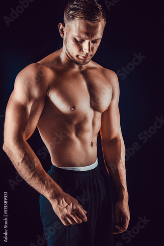 bodybuilder posing. Beautiful sporty guy male power. Fitness muscular body. Isolated on black background