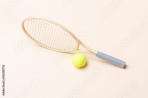 Beige tennis racket and yellow ball on beige background. Horizontal sport theme poster, greeting cards, headers, website and app.