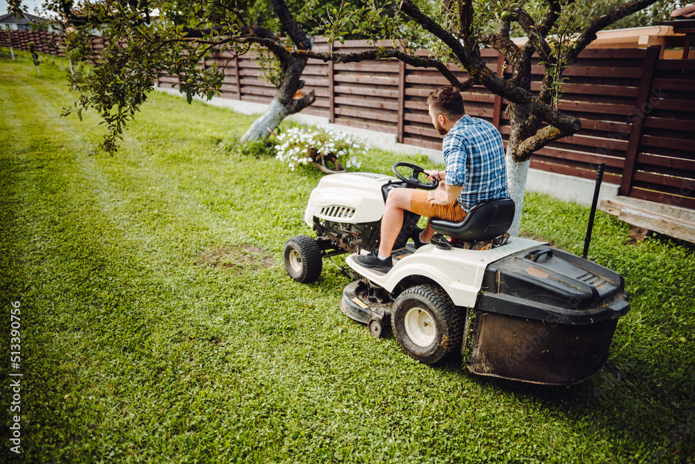 Gardening details with worker using lawn tractor Gardening details with worker using lawn tractor