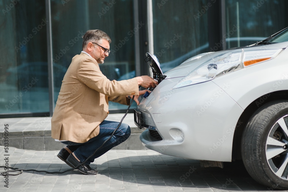 Man holding power connector for electric car Man holding power connector for electric car