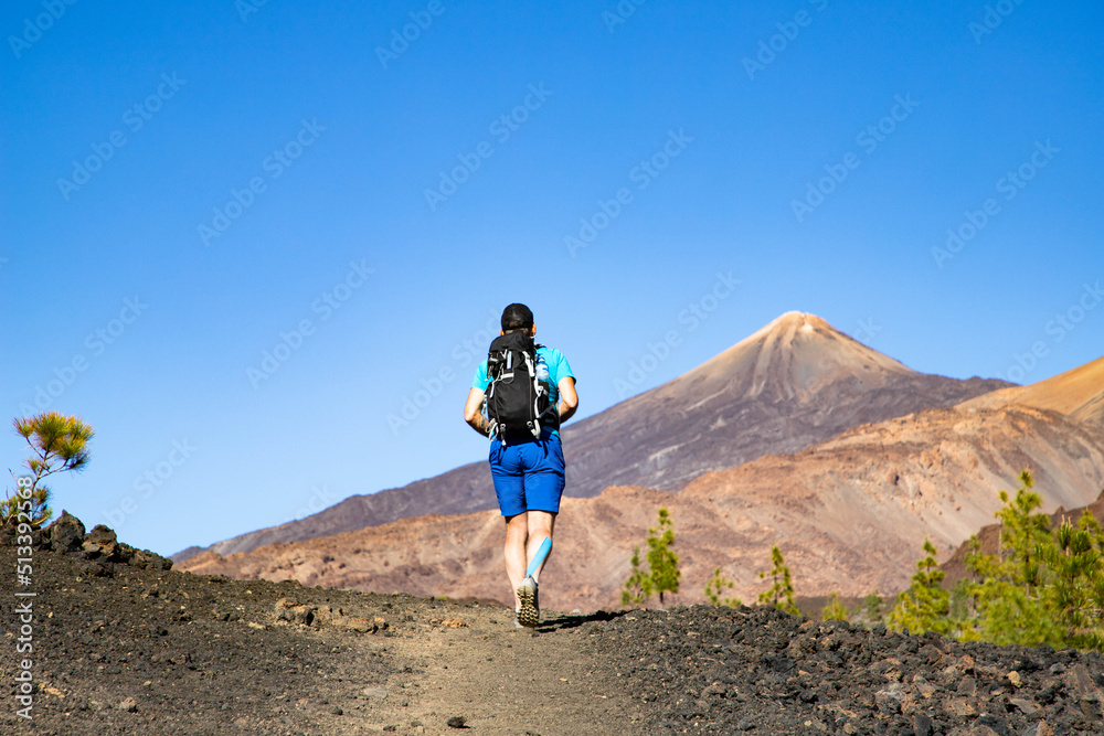 Fototapeta premium man hiking towards the volcano in El Teide national park Tenerife