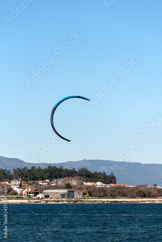 kitesurfing kite flying over clear skies inj the beach