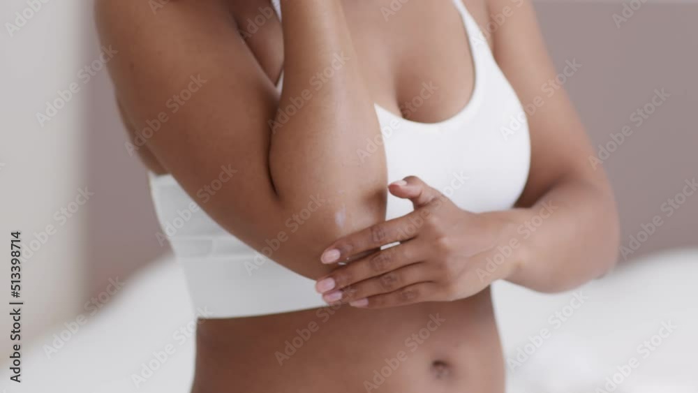 Dry skin treatment. Unrecognizable black woman in underwear applying moisturising soothing cream at elbow Dry skin treatment. Unrecognizable black woman in underwear applying moisturising soothing cream at elbow
