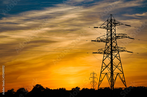 Canvas Print Silhouette of electricity pylon against a warm sunset over the English countryside