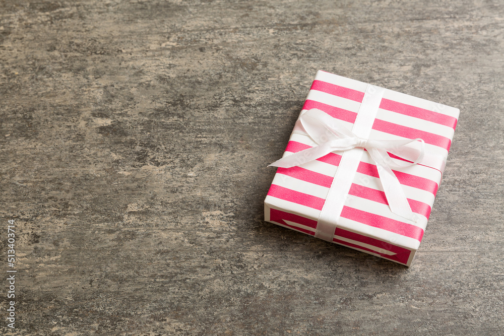 wrapped Christmas or other holiday handmade gift box in color paper with ribbon on colored background. Present box, decoration of gift on colored table, top view with copy space wrapped Christmas or other holiday handmade gift box in color paper with ribbon on colored background. Present box, decoration of gift on colored table, top view with copy space