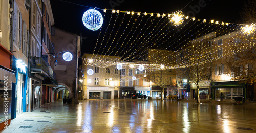 Fototapeta Naklejka Na Ścianę i Meble -  Scenic view of central street of small French town of Montelimar with bright colorful Christmas light decorations on winter twilight, Drome department