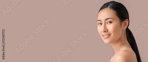 Portrait of beautiful Asian woman on beige background with space for text