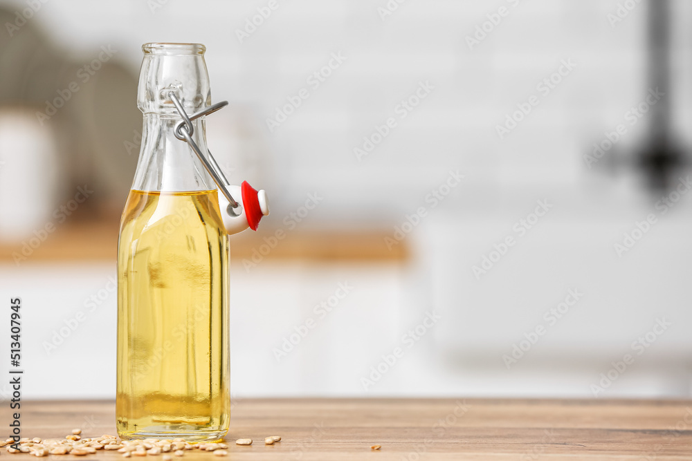 Bottle of oil with sunflower seeds on table in kitchen Bottle of oil with sunflower seeds on table in kitchen