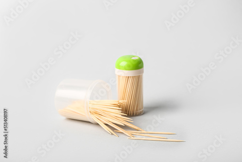 Holders with toothpicks on white background