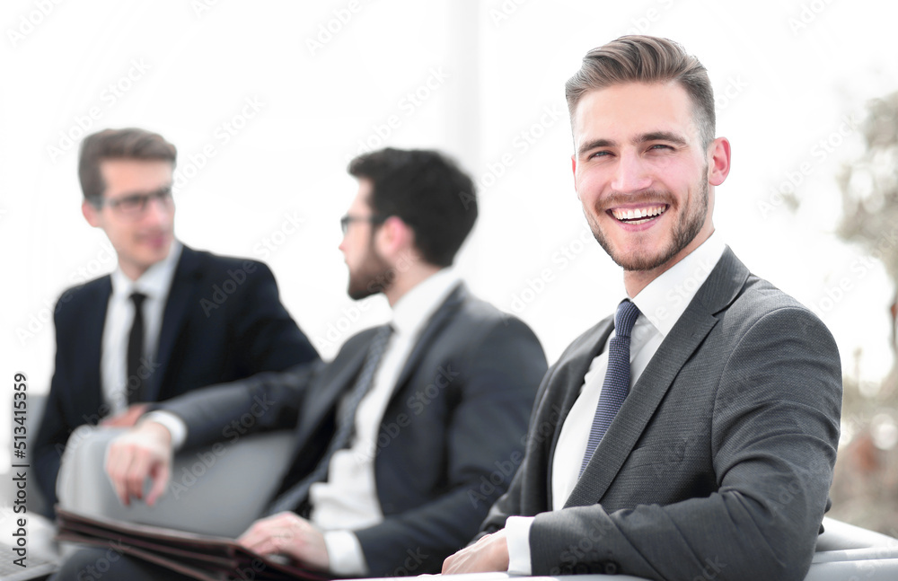 smiling businessman in the background of the office. smiling businessman in the background of the office.