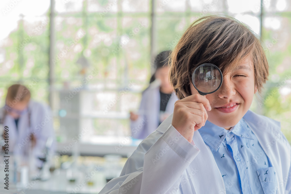 schoolboy holding a magnifying glass studying science schoolboy holding a magnifying glass studying science