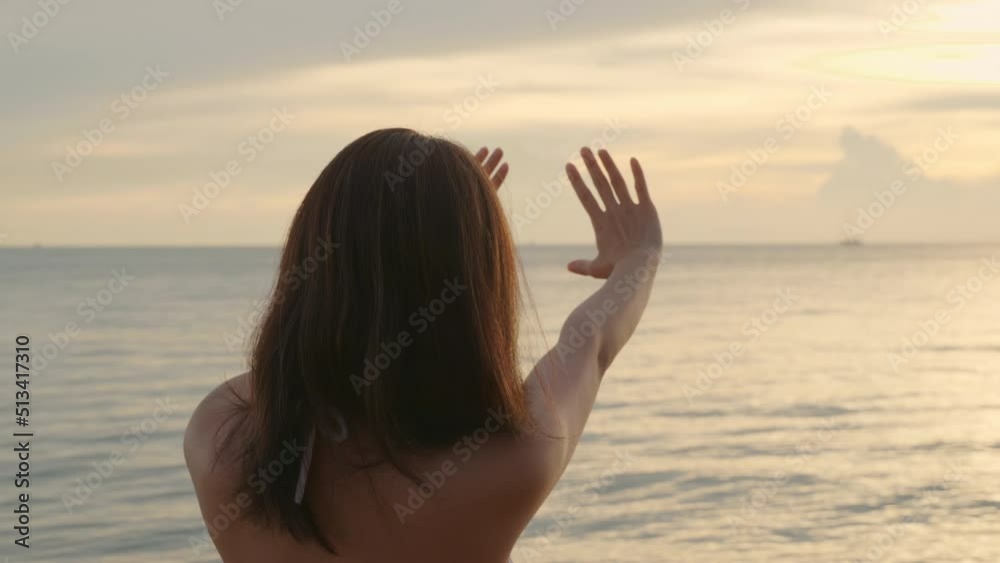 Back view, Beautiful woman wear bikini swimsuit making heart sign with hands at tropical beach, Happy Asian sexy female make shape with her fingers in holiday outside sunset, Summer travel vacation Back view, Beautiful woman wear bikini swimsuit making heart sign with hands at tropical beach, Happy Asian sexy female make shape with her fingers in holiday outside sunset, Summer travel vacation