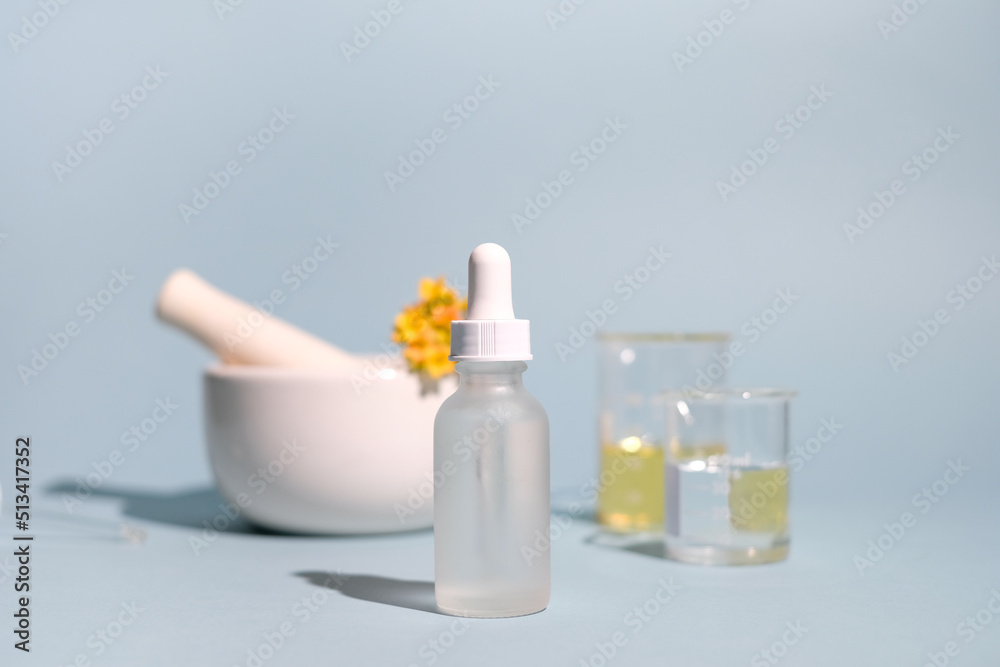 Natural cosmetic, skincare, and beauty product with oil, pestle, and mortar on blue background. clean beauty concept. Natural cosmetic, skincare, and beauty product with oil, pestle, and mortar on blue background. clean beauty concept.