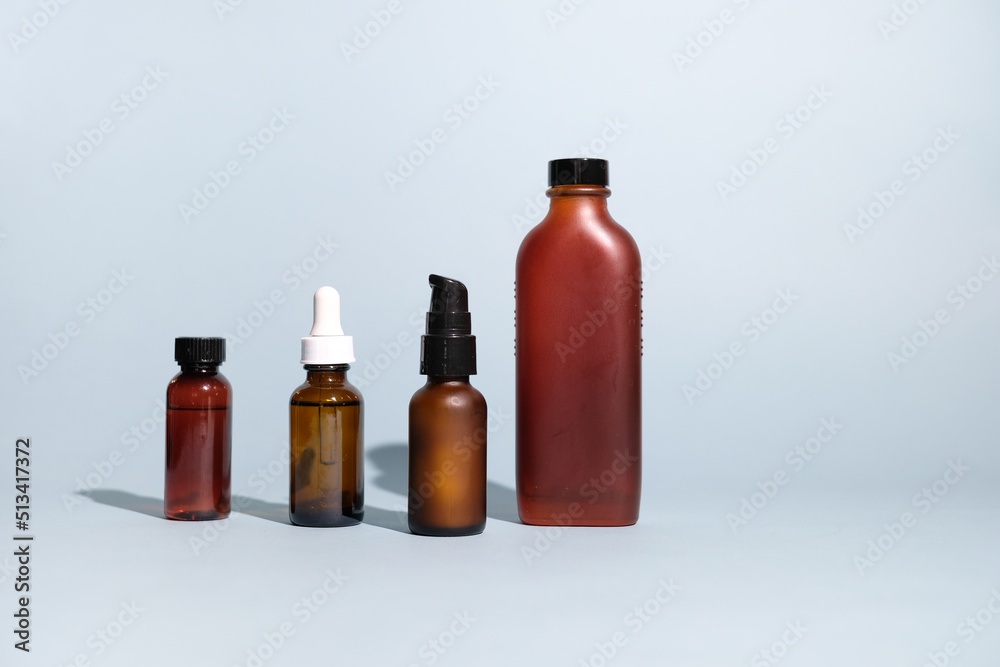 The set of amber glass bottles for skincare on blue background. mock-up and beauty concept. The set of amber glass bottles for skincare on blue background. mock-up and beauty concept.