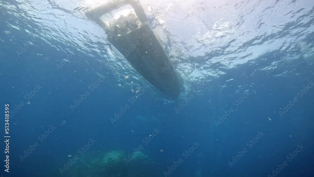 Under Water film of under angle view of diving boat and scuba divers at ko tao island in Thailand