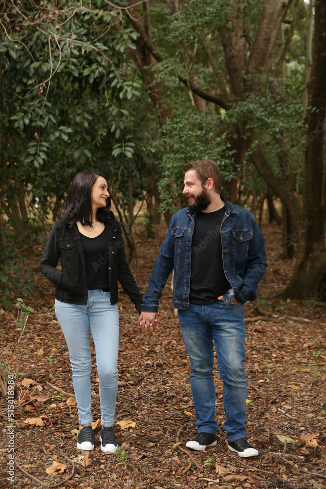 Portrait of a Cheerful Couple Looking Each Other at the Park. Romantic Relationship Concept. Portrait of a Cheerful Couple Looking Each Other at the Park. Romantic Relationship Concept.