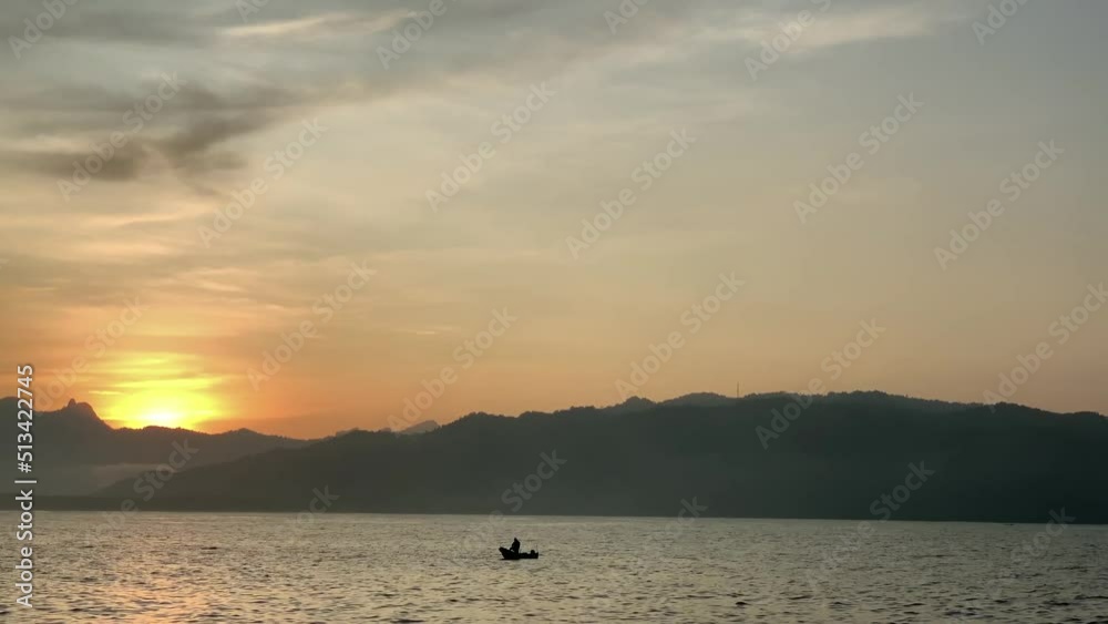 Landscape of the sea with Indonesian traditional fisherman preparing fishing nets on his wooden boat to catch fish