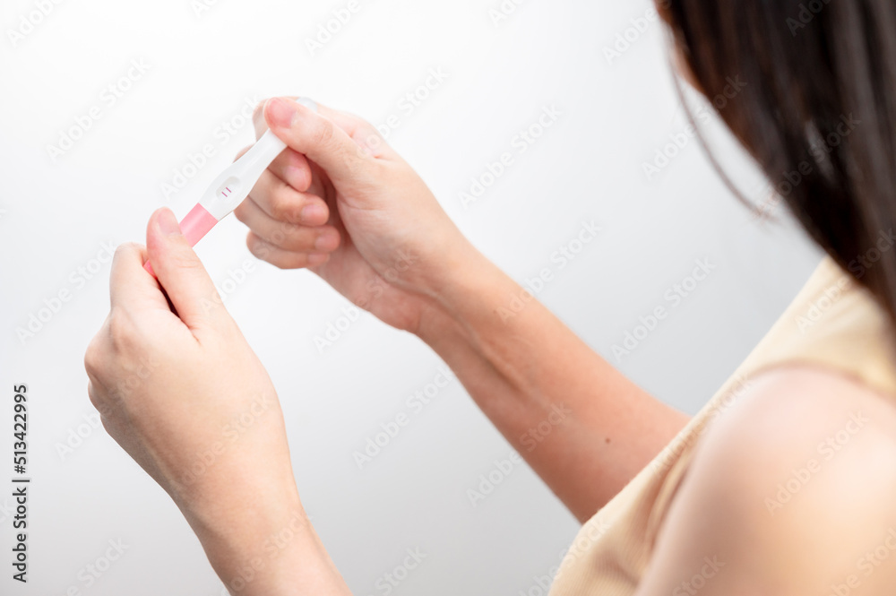  woman hand  holding pregnancy test. result female health problems and infertility. successful treatment IUI Intra – Uterine Insemination and ICSI. Pregnancy is not ready in adolescence..