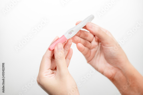  woman hand holding pregnancy test. result female health problems and infertility. successful treatment IUI Intra – Uterine Insemination and ICSI. Pregnancy is not ready in adolescence..