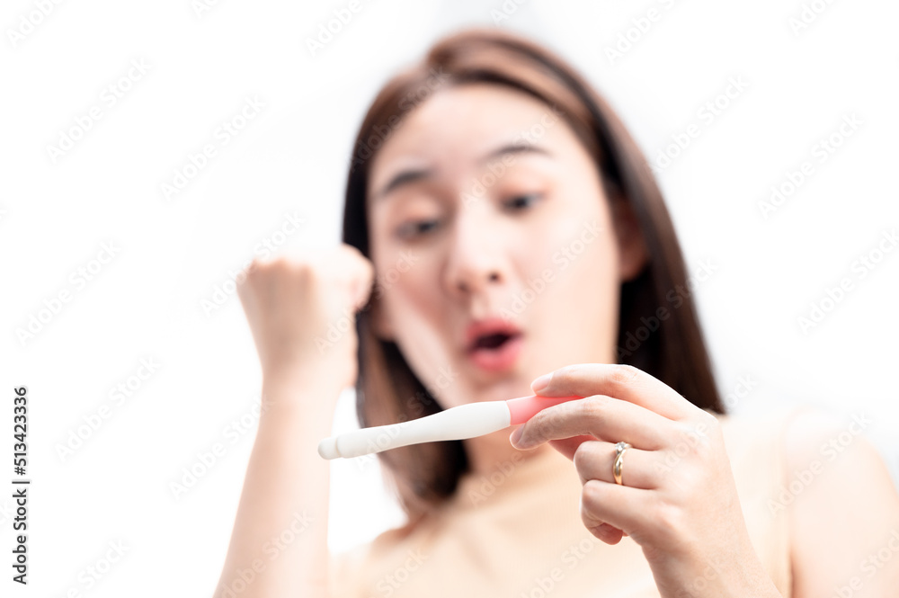 Asian woman holding pregnancy test feeling happy by positive result female health problems and infertility. successful treatment IUI Intra – Uterine Insemination and ICSI Asian woman holding pregnancy test feeling happy by positive result female health problems and infertility. successful treatment IUI Intra – Uterine Insemination and ICSI