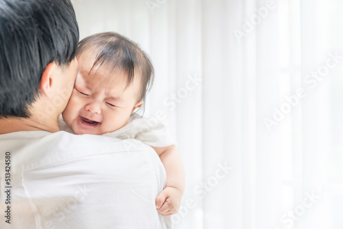 泣いている赤ちゃんを抱っこする男性