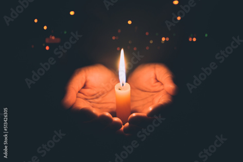Valokuvatapetti Woman hands praying in the light candles