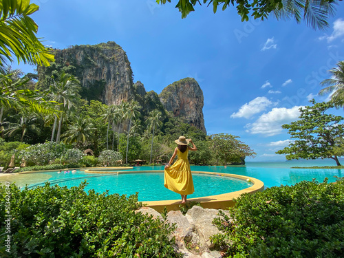 Woman tourist in yellow dress and hat traveling on Railay beach, Krabi, Thailand. vacation, travel, summer, Wanderlust and holiday concept photo