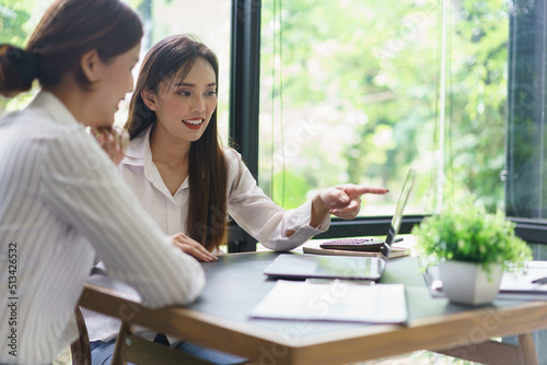 Free Download Coworker business concept, Businesswoman pointing chart on laptop to discussing project together - GFXLoad