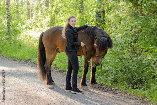 Icelandic horse on gravel road with young woman. Shot in the evening middle of the summersummer in Finland © AnttiJussi
