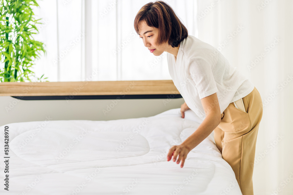 Young asian woman housewife clean bed and set up changing bedsheet with white clean sheet tidy up bedroom.room service and cleaning concept Young asian woman housewife clean bed and set up changing bedsheet with white clean sheet tidy up bedroom.room service and cleaning concept