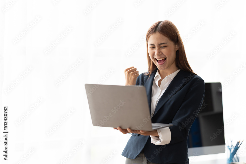 Portrait of an excited young asian business woman holding laptop computer and celebrating success isolated over white background, copy space. Portrait of an excited young asian business woman holding laptop computer and celebrating success isolated over white background, copy space.